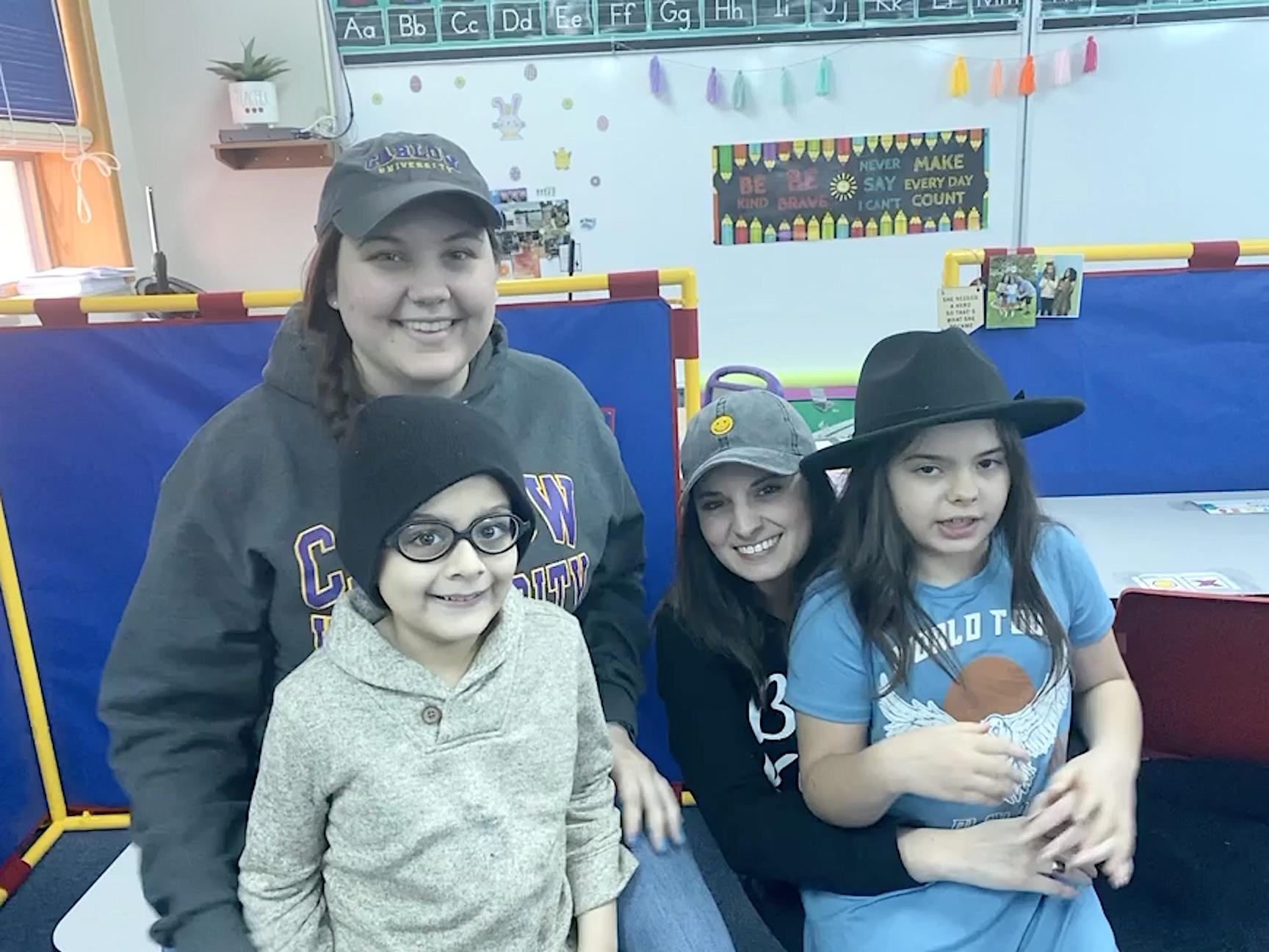 Miss Kochasic, Hassan Malik (grade 1), Miss Freger, and Gianna Acker (grade 4) on hat day