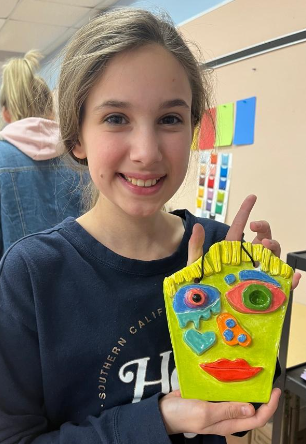 Sunrise 5th-grader Niomi Kearns displays her clay face sculpture