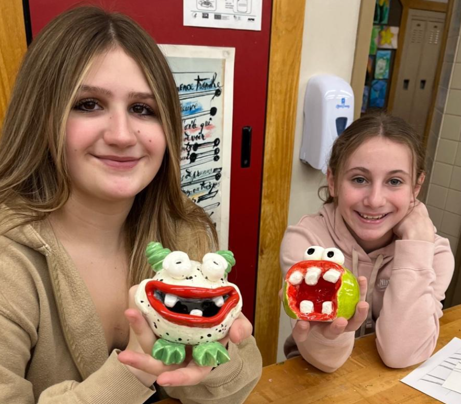 Penn Middle 7th-graders Madison Bartling and Juliana Reilly hold their finished monster sculptures
